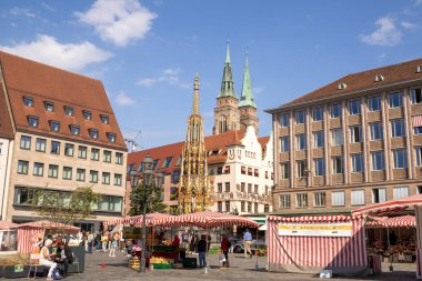 Almanya 'nın Nuremberg şehrinde Hauptmarkt' ta Schner Brunnen çeşmesi ve St. Sebald Kilisesi 'nin ikiz kuleleri yer alıyor..