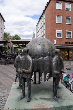 Kaiserstrae, Nuremberg, Bavyera, Almanya 'daki Bronz Welthandel heykeli, popüler tarihi bir alışveriş caddesinde ayrıntılı dokular ve canlı şehir atmosferiyle yakalandı..
