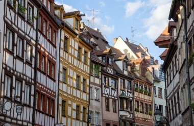 Nuremberg, Bavyera, Almanya 'daki Weigerbergasse caddesi boyunca uzanan renkli geleneksel kereste çerçeveli evler, pitoresk bir eski kasaba ortamında büyüleyici bir ortaçağ mimarisi sergiliyor..