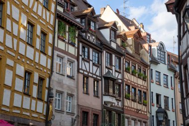 Nuremberg, Bavyera, Almanya 'daki Weigerbergasse caddesi boyunca uzanan renkli geleneksel kereste çerçeveli evler, pitoresk bir eski kasaba ortamında büyüleyici bir ortaçağ mimarisi sergiliyor..