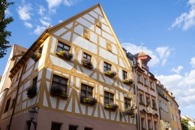 Nuremberg, Bavyera, Almanya 'daki Weigerbergasse caddesi boyunca uzanan renkli geleneksel kereste çerçeveli evler, pitoresk bir eski kasaba ortamında büyüleyici bir ortaçağ mimarisi sergiliyor..