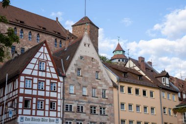 Nurembergs 'deki renkli Bavyera kereste iskeleli evler Kaiserburg Kalesi ve Sinwell Kulesi' nin yükseldiği Tiergrtnertorplatz, Almanya 'nın tarihi manzarası..