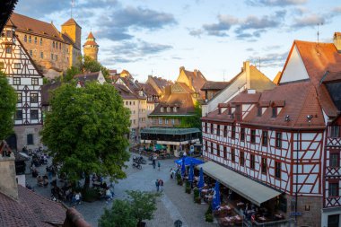 Tiergrtnertorplatz 'daki renkli Bavyera kereste iskeleli evler Nuremberg Kalesi ve Sinwell Kulesi, tarihi ahşap duvar geçidi manzaralı
