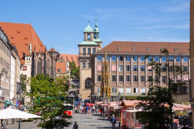Almanya 'nın Nuremberg şehrinde Hauptmarkt' ta Schner Brunnen çeşmesi ve St. Sebald Kilisesi 'nin ikiz kuleleri yer alıyor..
