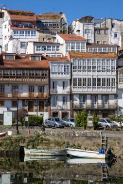 Praza 'dan manzara Enrique Ivntiga Eira Vella, Betanzos, Galiçya, nehir kenarındaki beyaz evler ve huzurlu Mandeo Nehri' ni yansıtan tekneler.