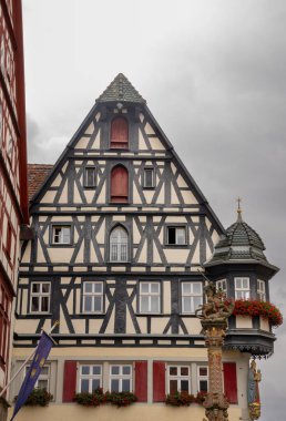 Rothenburg ob der Tauber, Almanya Pazar Meydanı, tarihi belediye binası kulesi, Ratstrinkstube Saat Kulesi, yarım kereste evler, kaldırım taşı sokaklar, Bavyera kentinde çeşme ve dükkanlar.