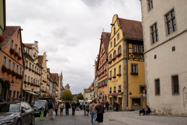 Rothenburg ob der Tauber, Almanya Pazar Meydanı, tarihi belediye binası kulesi, Ratstrinkstube Saat Kulesi, yarım kereste evler, kaldırım taşı sokaklar, Bavyera kentinde çeşme ve dükkanlar.