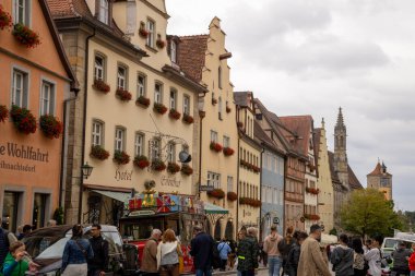Rothenburg ob der Tauber, Almanya Pazar Meydanı, tarihi belediye binası kulesi, Ratstrinkstube Saat Kulesi, yarım kereste evler, kaldırım taşı sokaklar, Bavyera kentinde çeşme ve dükkanlar.