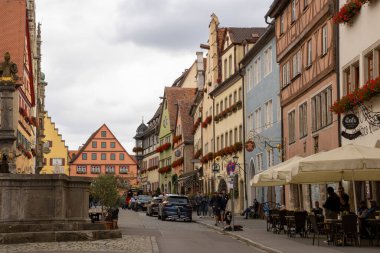Herrnbrunnen şelalesi ve Rothenburg ob der Tauber, Bavyera, Almanya 'da geleneksel yarı ahşap binalar ile renkli tarihi Herrngasse caddesi, ortaçağ şehir seyahat sahnesi.