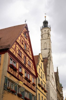 Herrnbrunnen şelalesi ve Rothenburg ob der Tauber, Bavyera, Almanya 'da geleneksel yarı ahşap binalar ile renkli tarihi Herrngasse caddesi, ortaçağ şehir seyahat sahnesi.