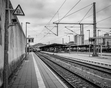 Boş Tren Platformu Rayları Tepedeki Kablolar, Moody Bulutlu Gök Çerçevesi Uzak Sinyal ve Çelik Kateneri, Öncü Hatlar Ufuk 'a, Beton' a,