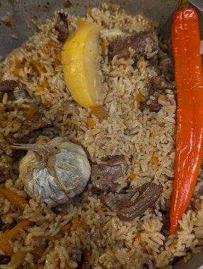 Pilav, kuzu eti, sarımsak, limon dilimli havuç, sarımsak, sarımsak, uzun kızarmış havuç, yumuşak et parçaları, baharatlar ve yağlı yağlı,