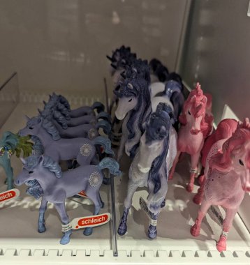 Pforzheim Almanya 25 Şubat 2026 Pastel Plastik Midilli Figürleri Beyaz Market Rafında Görünür Fiyat etiketleri, Lavanta ve Allık Renkler, Parlak Bitiş,