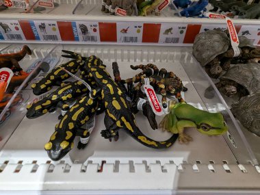 Pforzheim Almanya 25 Şubat 2026 Rafta Semender Artılarını Mağazada, Parlak Sarı ve Siyah Benekli Oyuncaklar Plastik tepside, Yeşil Kurbağa figürlü tünemiş,