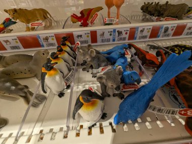 Pforzheim Almanya 25 Şubat 2026 Rafta, Plastik Macaw 'da ve çeşitli dinozor modelleri ve hayvan minyatürleri arasında Toucan figürleri sergilendi.