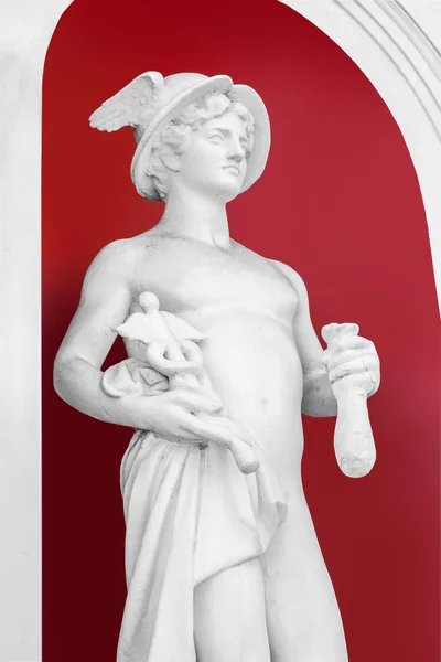 Bílá socha Bůh Hermes na pozadí natřené červenou zeď — Stock fotografie