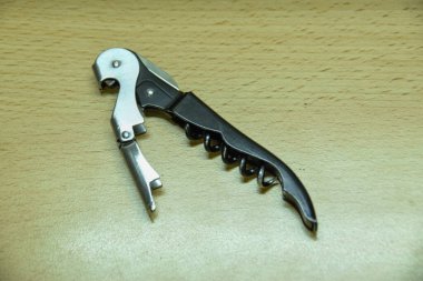 Tirbuşonlu şarap bıçağı, şişe açacağı, garsonun şarap açacağı, masanın üstünde.