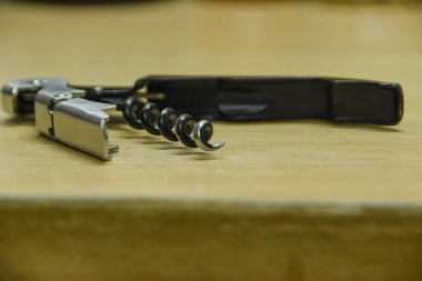 Tirbuşonlu şarap bıçağı, şişe açacağı, garsonun şarap açacağı, masanın üstünde.