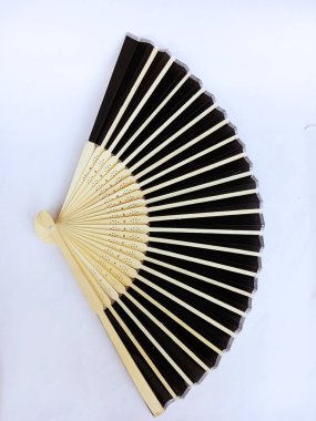 Beyaz zemin üzerinde kahverengi ahşap saplı siyah el bilgisayarı pervanesi açık bir ekranda, karmaşık katlar ve zarif işçilikle gösteriliyor. Açılan veya yayılan tavus kuşu tüylerinin şekli.