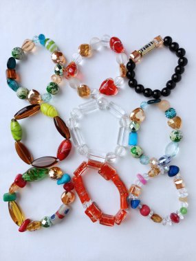 Bir grup renkli Afrika boncuk bileziği beyaz arka planda güzelce yerleştirilmiş. Bir sürü farklı boncuklu bileziğin görüntüsü.