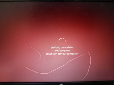 Bilgisayarı yeniden başlatmadan önce güncellemeler üzerinde çalışıyorum. Kırmızı arkaplanlı ekranda yükleme yüzdesi gösteriliyor. Yeniden başlat, sayfayı daire şeklinde yeniden başlat. Sakın kapatma..