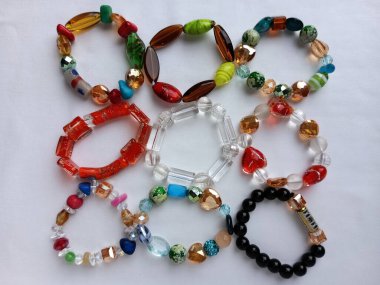 Bir grup renkli Afrika boncuk bileziği beyaz arka planda güzelce yerleştirilmiş. Bir sürü farklı boncuklu bileziğin görüntüsü.