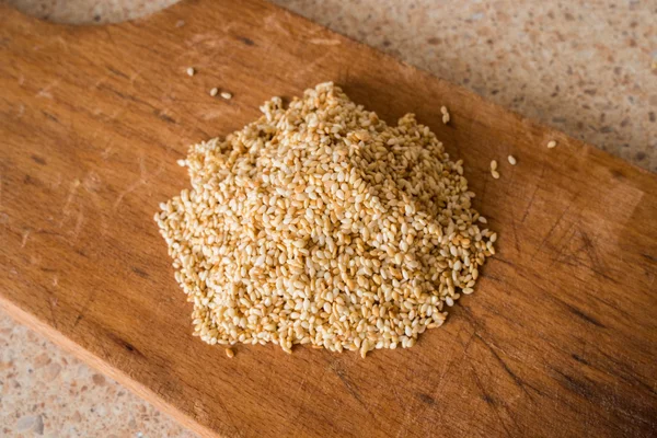 A handful of sesame seeds is bitter on wooden Boards — Stock Photo, Image