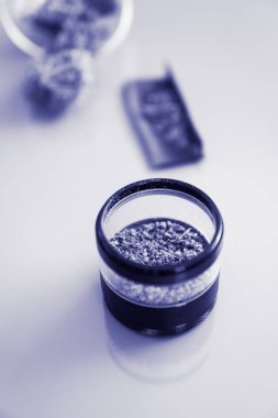 Öğütücü ve esrar otu tomurcuğu. Beyaz arka plan. Marihuana doğa otu. Esrar, THC CBD 'nin üzerinde kalıyor. Dikey çekimi kapat. Indica Sativa Tıbbi Sağlık.