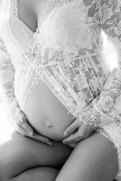Вагітна жінка тримає живіт. Живіт вагітної жінки на білому тлі, дев'ять місяців . — стокове фото