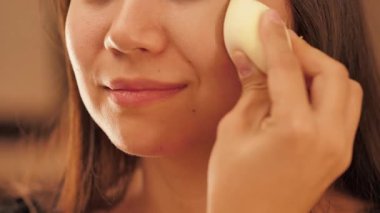 Güzellik derisi ve makyaj rutini yapan bir kadın, rimel, göz kalemi, dudak parlatıcısı, toner ve fondöten sürmüş. Güzellik dersleri, kozmetik ve kişisel bakım için mükemmel bir konsept.