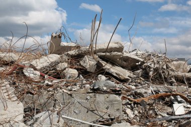 İnşaat enkazı, paslanmış metal çubuklar ve çatlamış beton levhalar. Ruh hali, yıkım ve yıkım izlenimi veriyor. Ama sahnede engebeli bir güzellik var. İzole edilmiş ortam, insan yapımı kaosun ve doğal güzelliğin etkileşimini vurguluyor..