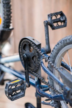 Tozlu bisiklet pedalının, zincirin ve zincirlemenin yakın çekimi, yıpranmış ve iyi kullanılmış mekanik sürücü tren parçalarını gösteriyor