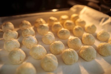 Pişmemiş hamur topları geleneksel Bulgar solenki tuzlu peynirli hamur işleri için yumuşak odak ve doku detayı içeren fırın örtüsüne dizilmiştir.