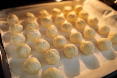 Pişmemiş hamur topları geleneksel Bulgar solenki tuzlu peynirli hamur işleri için yumuşak odak ve doku detayı içeren fırın örtüsüne dizilmiştir.