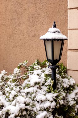 Klasik kara bahçe feneri kış karı yağışında taze karla kaplanmış, açık hava dekoratif sokak lambası yerleşim alanında, soğuk hava mevsimsel atmosfer