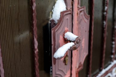 Eski ahşap kapı kolunda kar kaplı metal kapı kulpu, donmuş desenli kış detayları, yakın kırsal giriş, fotokopi alanı olan soğuk hava arkaplanı