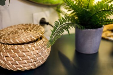 Siyah yüzey üzerinde eğreltiotu olan dokuma sepeti