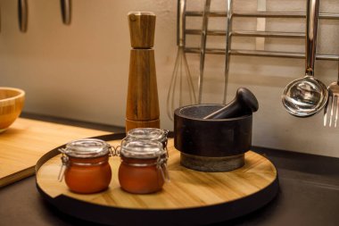 Mutfak tezgahı ahşap havan ve baharatlarla dolu.