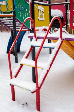 Metal çocuk parkı merdiveni kışın taze karla kaplı. Soğuk kar yağışı sırasında boş şehir parkı ekipmanları