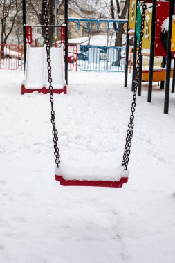 Şehir merkezinde kış aylarında kar yağarken boş salıncağın etrafı karla kaplıydı.