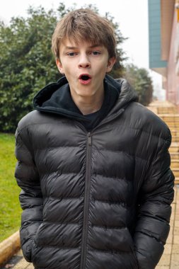 Parkta şaşırmış bir gencin açık hava portresi, duygusal gençlik anı ve otantik şehir yaşam tarzı.