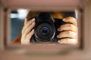 Profesyonel bir kamera tutan fotoğrafçıların elleri, çerçeve merkezli, yaratıcı görüş ve modern fotoğrafçılık kavramını yakalıyor.