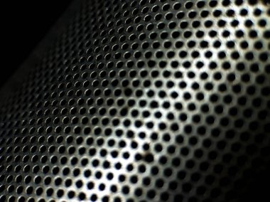 Perforated metal sheet with a grid of evenly spaced circular holes, creating a lattice pattern. 