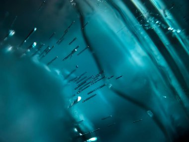 Rippling blue ice cube creates a dynamic abstract background.