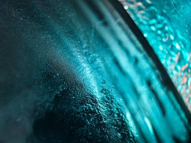 Rippling blue ice cube creates a dynamic abstract background.