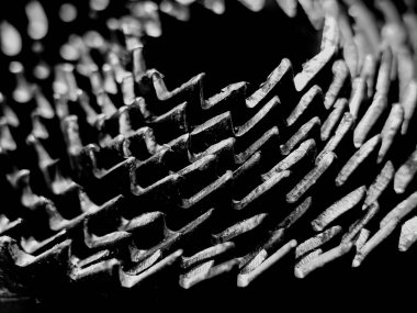 Yuvalanmış delik testerelerinin yakın plan çekimi spiral bir düzende, keskin, tırtıklı kenarları gösteriyor.. 