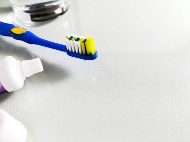 Beyaz ve sarı tüylü mavi çocuk diş fırçası açık renkli bir yüzeyde yatıyor..