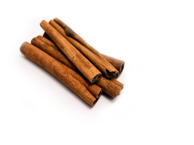 Beyaz arkaplanda duran birkaç tarçın çubuğunun yakın plan görüntüsü