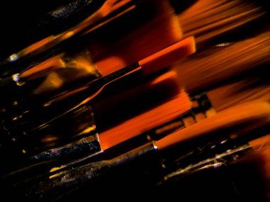 Orange brush tips set against a dark background, creating an abstract composition.