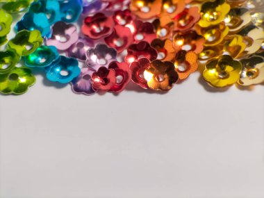 Küçük çiçek şeklinde renkli pullar, soyut ve canlı bir arkaplan oluşturmak için örtüşüyor. 